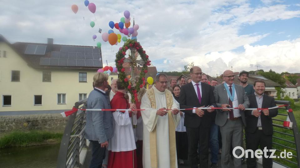 Die Ehrengäste durchtrennen das symbolische Band. Die neue Fußgänger- und Radlbrücke über die Schwarzach ist eröffnet. Bild: mad