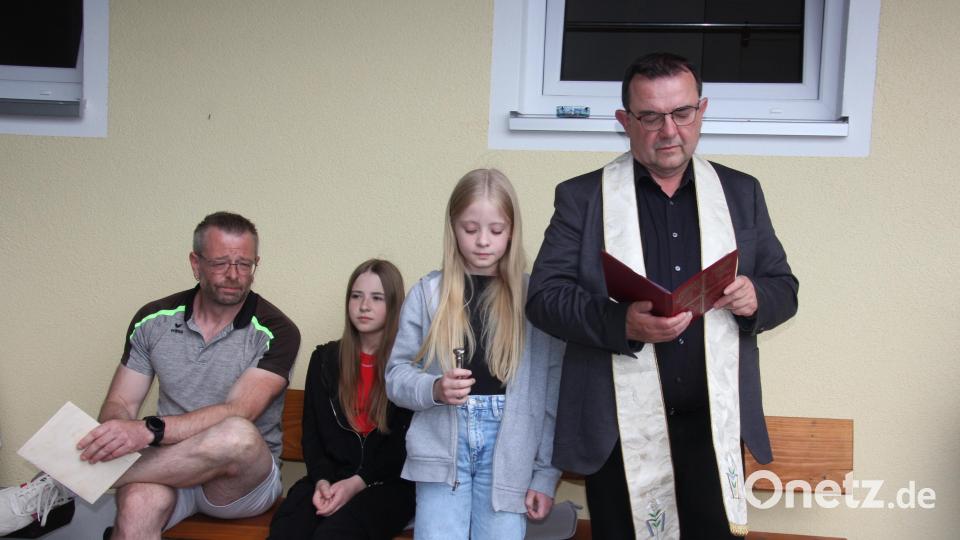 Stadtpfarrer Konrad Amschl bei seiner Ansprache vor der Segnung des neuen Vereinsheims des TC Bärnau. Links sitzend Spartenleiter Christian Walter. Bild: kro