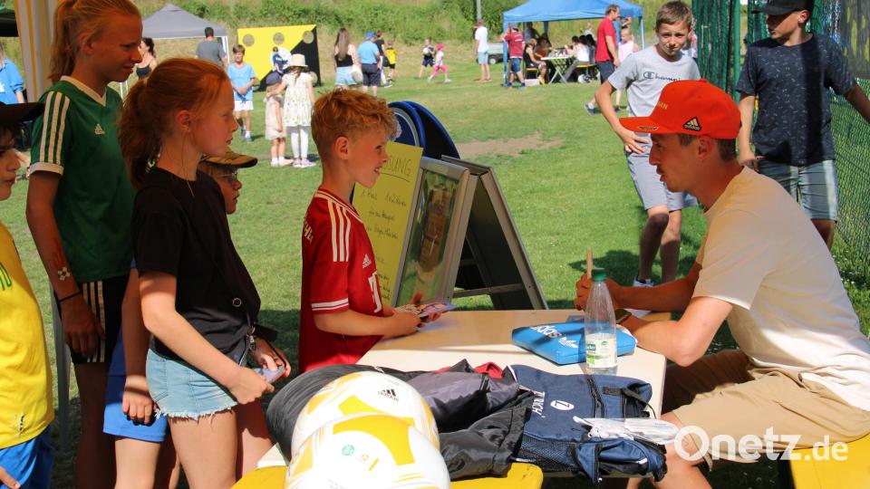 Eric Frenzel signiert allerhand Dinge, die im die Kinder vorlegen Bild: prh