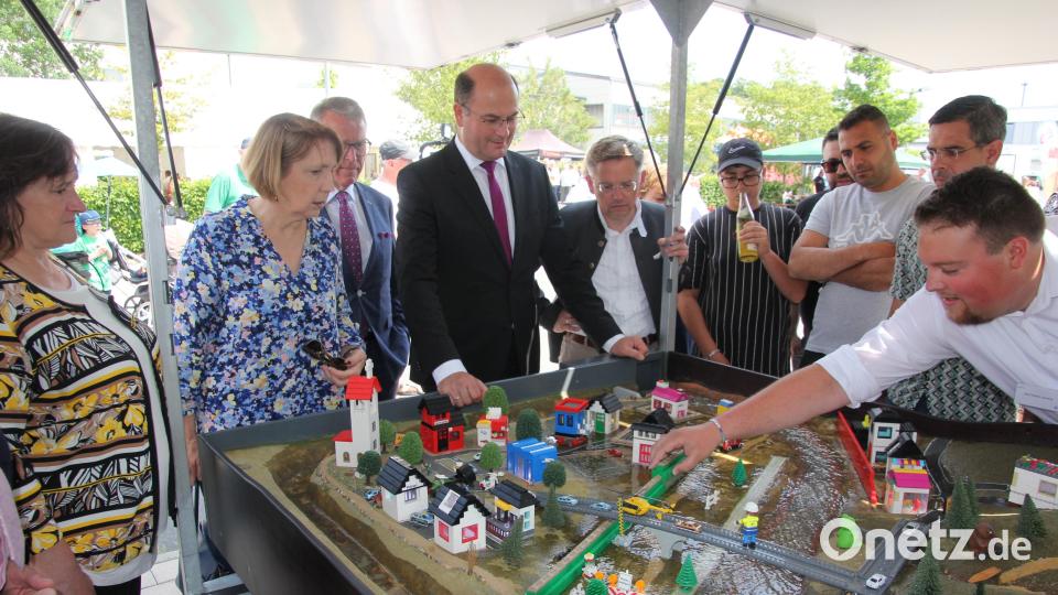 Die Besucher und Ehrengäste um Heimatminister Albert Füracker (Mitte) schauen sich die Simulation eines Hochwassers und eines Überschwemmungsszenarios an. Bild: kro