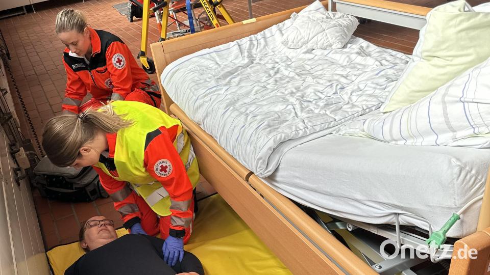 Svenja Schwarz (gelbe Weste) versorgt in ihrer praktischen Prüfung zusammen mit ihrer Teampartnerin Regina Mayerhofer ein Sturz aus dem Bett. Bild: BRK Kreisverband Tirschenreuth/exb