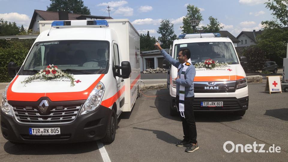 Gesegnet wurden die neuen Fahrzeuge - eines für den Betreuungsdienst (links) und das andere für den Katastrophenschutz (rechts) - von Pfarrvikar James George. Bild: wro