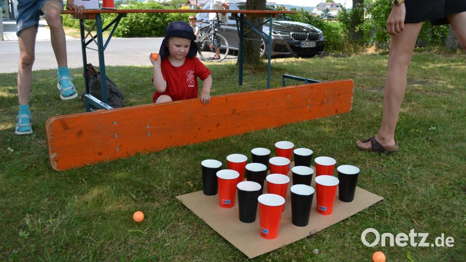 Unter dem Schatten der Bäume vor dem Pfarrheim war genaues Zielen angesagt: Der Tischtennisball musste in die Becher befördert werden. Bild: kki