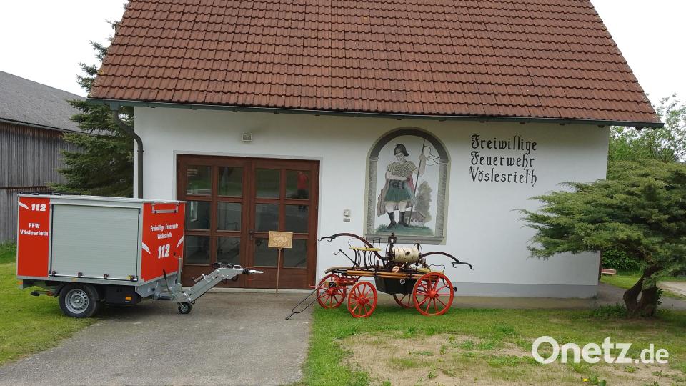 Die technische Entwicklung bei der Feuerwehr Vöslesrieth wird vor dem Feuerwehrhaus sichtbar: Der neue Löschanhänger wird im Rahmen des Festgottesdienstes zum 125. Jubiläum geweiht, die alte Pumpe mit Handbetrieb erinnert an die Gründungsjahre der Wehr. Bild: bey
