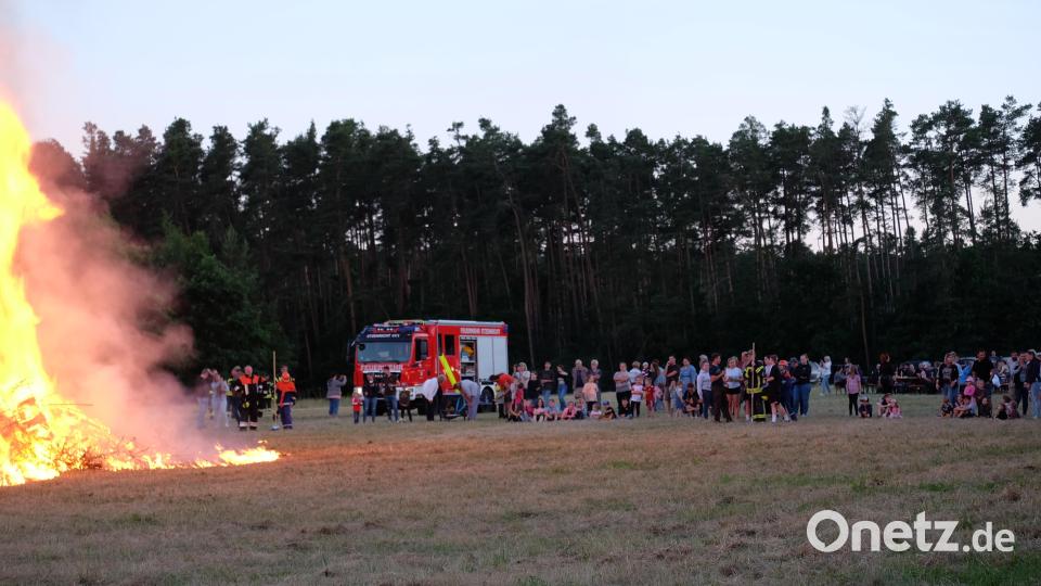 Beim Entzünden des Feuers zog es die Besucher näher an die Feuerstelle zu gehen. Die Feuerwehr kümmerte sich, dass auch genügend Abstand gehalten wurde. Bild: wlr