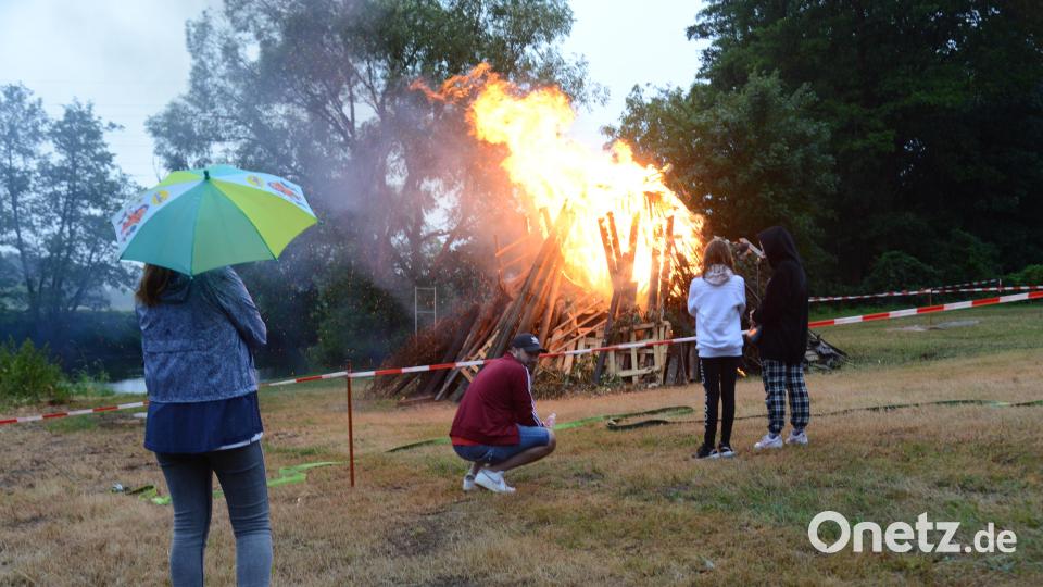 Ein Regenschirm empfahl sich für diejenigen, die sich unter der Brücke herauswagten und sich dem Johannisfeuer näherten. Bild: bey