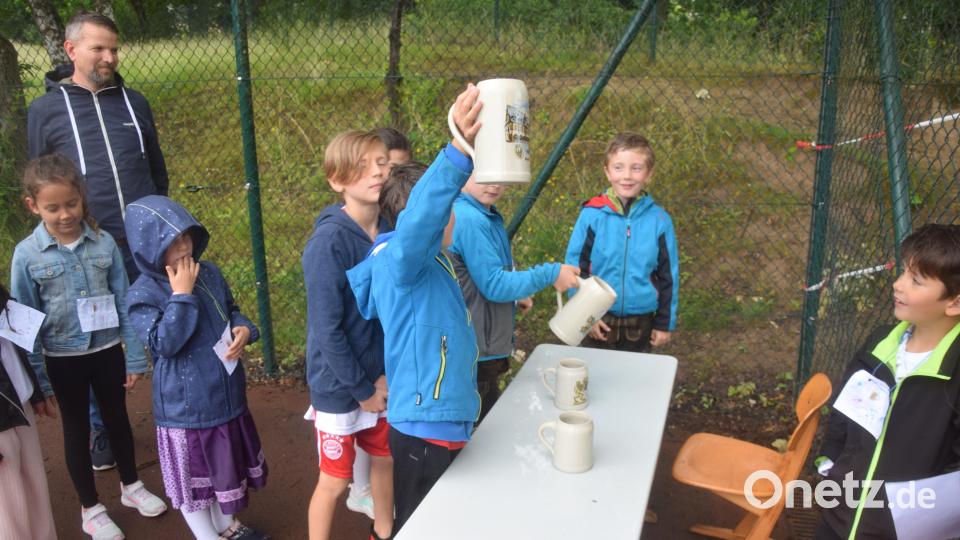 Hoch die Krüge, hieß es beim Masskrugstemmen. Die Kinder schlagen sich wacker. Bild: fz