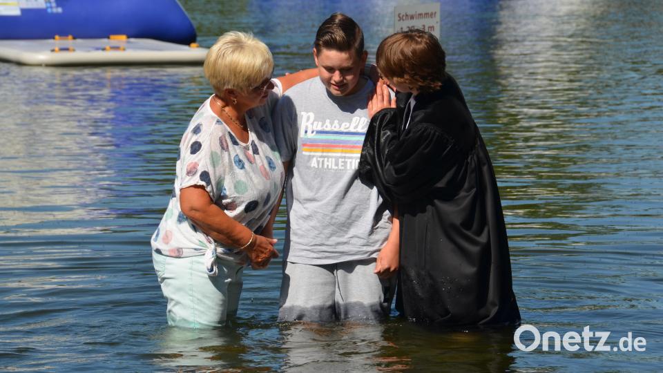 Voll Vertrauen gab sich der Junge in die Hände seiner Patin und Stadtpfarrerin Carmen Riebl und ließ sich völlig im Freibadwasser untertauchen. Bild: dob