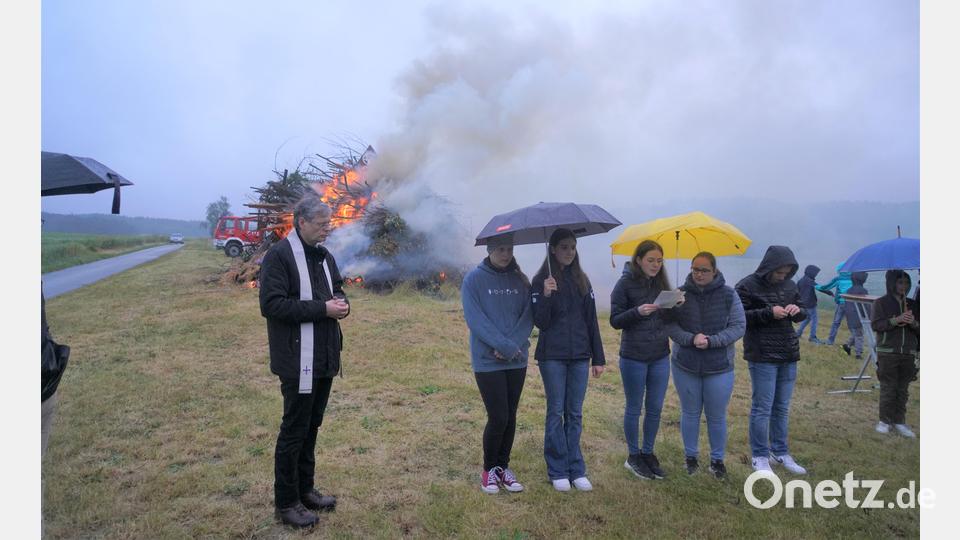 Pfarrer Norbert Götz segnet bei Regen das Johannisfeuer bei Woppenrieth Bild: fvo