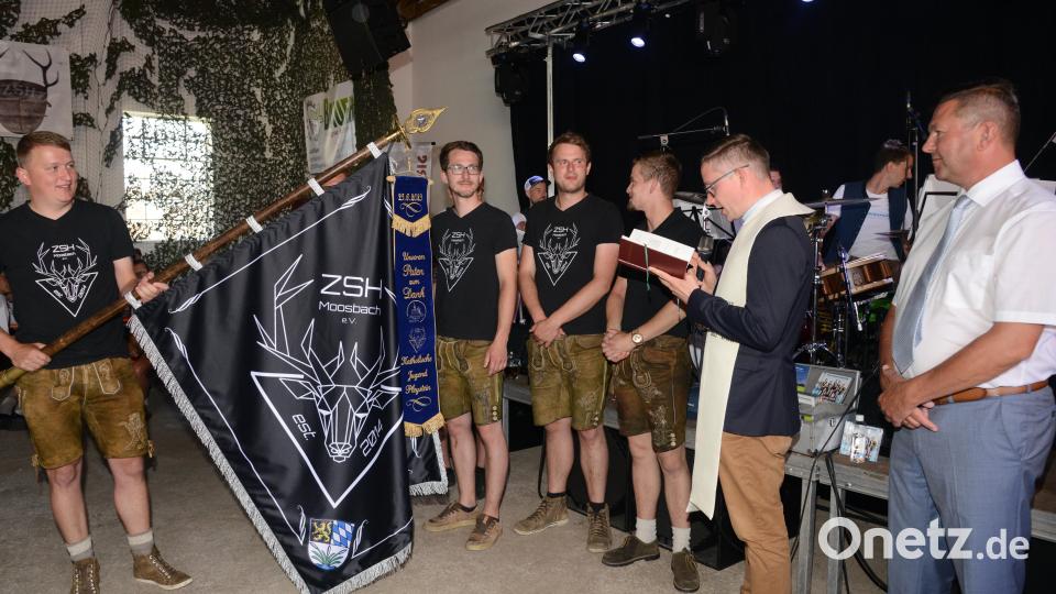Stadtpfarrer Adam Karolczak segnet in der Wassermann-Halle das Erinnerungsband, das die Katholische Jugend Pleystein dem Patenverein ZsH Moosbach übergibt und an deren Fahne hängt. Bild: bey