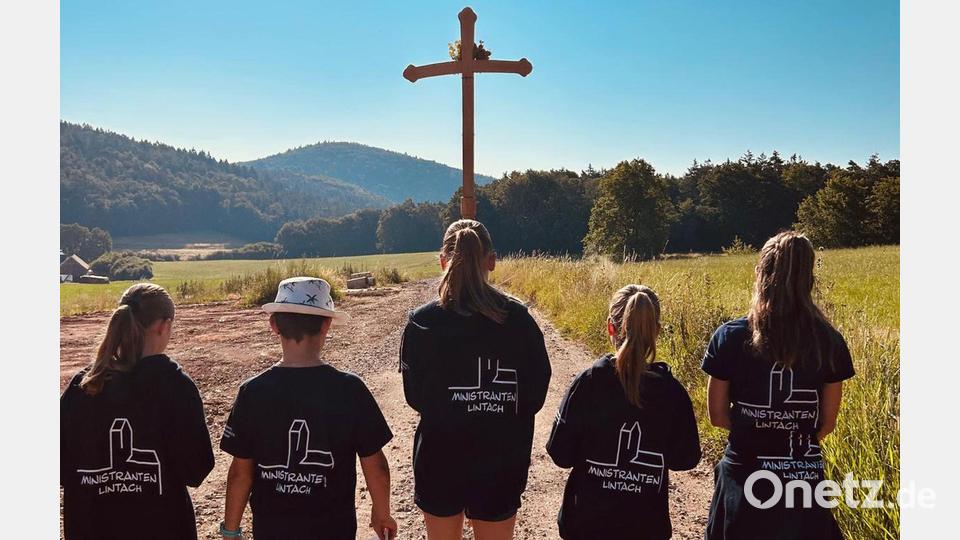 Den Johannisberg schon vor Augen haben die Lintacher Fußwallfahrer am Sonntagmorgen. Die Ministranten tragen das Kreuz voraus Bild: gri