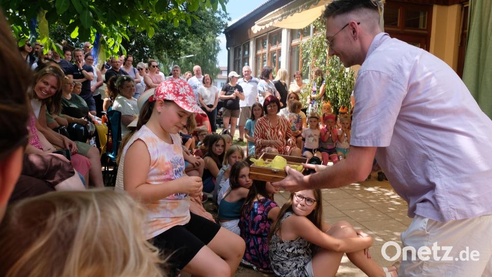 Leiter Sebastian Reil (rechts) stellt Quizfragen um den Kindergarten und verteilt die Gewinnlose. Bild: le