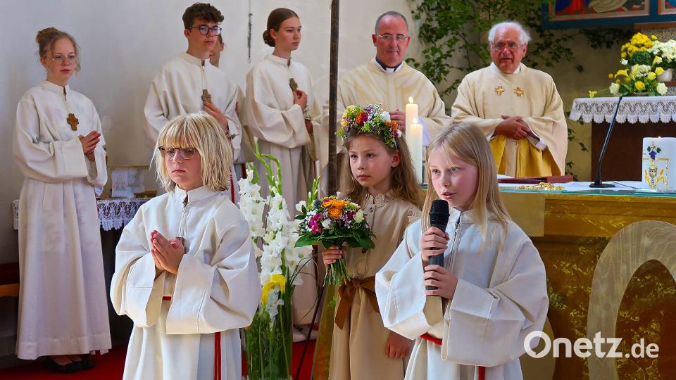 Vor dem Hochaltar überraschten zu Beginn des Festgottesdienstes Leonie Trießl sowie Amila und Alina Rohrer (von links) Priester und Bischöfe mit Gedichten und Blumen. Bild: bsc