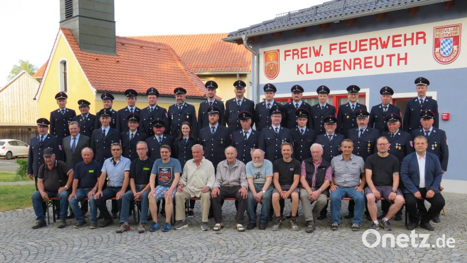 Die ältesten passiven Mitglieder sowie Ehrenmitglieder und die aktive Truppe der Klobenreuther vor dem erweiterten Feuerwehrhaus. Die Marien-Kapelle l (links), schon fast 150 Jahre alt, ist im Zuge der Gerätehauserneuerung ebenfalls renoviert worden. Vor dieser Kulisse wird auch der Festgottesdienst am Sonntag, 2. Juli, gefeiert. Bild: adj