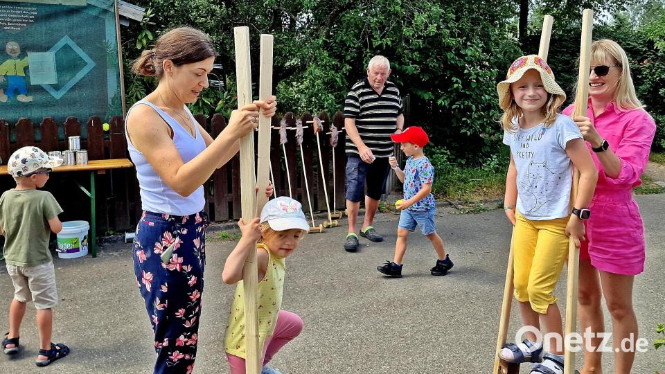 Stelzengehen beim Spielplatzfest – ein Riesenspaß für die Kinder. Karl Zitzmann (hinten) freut sich, dass das Fest doch noch zustande kam. Bild: R. Kreuzer
