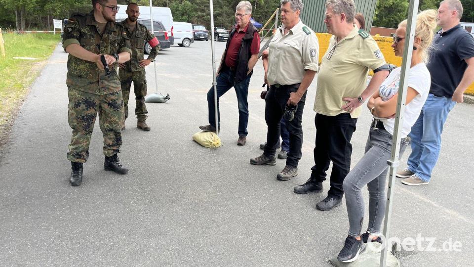 Oberfeldwebel Paul Ulbricht (links) weist zivile Gäste und Beamte des Bundesforstbetriebs in die Handhabung der Pistole P 8 ein. Bild: mor