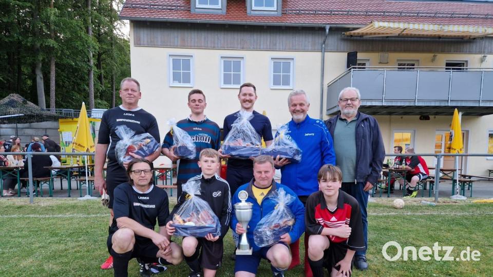 Den Siegern des Fußball-Gemeinde-Turniers gratulieren (stehend, links) Zweiter Vorsitzender Thomas Nitzbon, (stehend, rechts) Dritter Bürgermeister und Ehrenvorsitzender Erhard Nitzbon und (knieend, links) der Vorsitzende Thomas Melzer. Bild: ndt