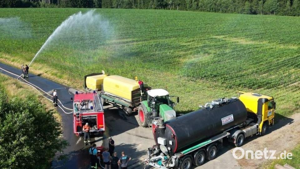 Zwei Landwirte unterstützen die Feuerwehrübung mit großen Wasserbehältnissen. Bild: gz