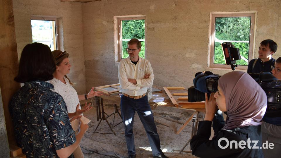 Bauleiterin Marlene Dorbach, Architektin und Lehmbauerin, erklärt den Gästen, welche Baumaterialien verwendet wurden und noch eingesetzt werden. Bild: szl