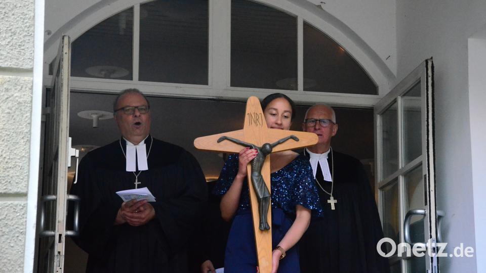 Dekan Thomas Guba und Regionaldekan Klaus Stiegler (von links) verlassen mit dem Kreuz das Evangelische Vereinshaus. Bild: Kunz