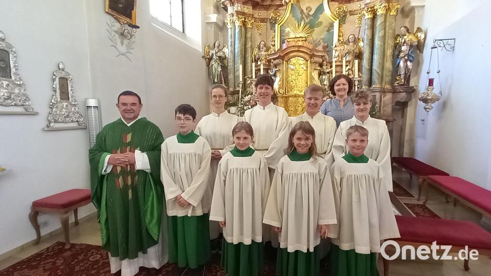 Pfarrer Konrad Amschl (links) und Pastoralreferentin Maria Wagner (hinten rechts) hießen mit Laura Schedl und Leni Rüth (vorne Mitte) zwei neue Messdiener in der Schar der Schwarzenbacher Ministranten willkommen. Bild: Pfarreiengemeinschaft Bärnau-Hohenthan-Schwarzenbach