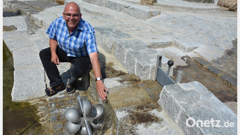 Bürgermeister Klaus Meyer zeigt ein Wasserrad auf dem Wasserspielplatz. Bild: jr
