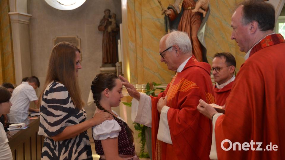 Zusammen mit ihren Paten schreiten die jungen Christen einzeln vor den Firmspender, Prälat Johannes Neumüller. Bild: dob
