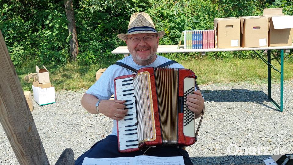 Andreas Zwicknagel begrüßt die Besucher des Museums musikalisch und bietet ihnen Notenhefte mit Volksliedgut aus der Oberpfalz an. Bild: jua