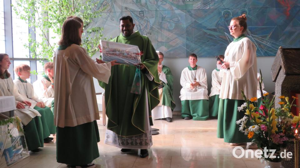 Die Ministranten überreichen Pfarrvikar Thomas Kutty Samuel zum Abschied ein Geschenk. Bild: adj