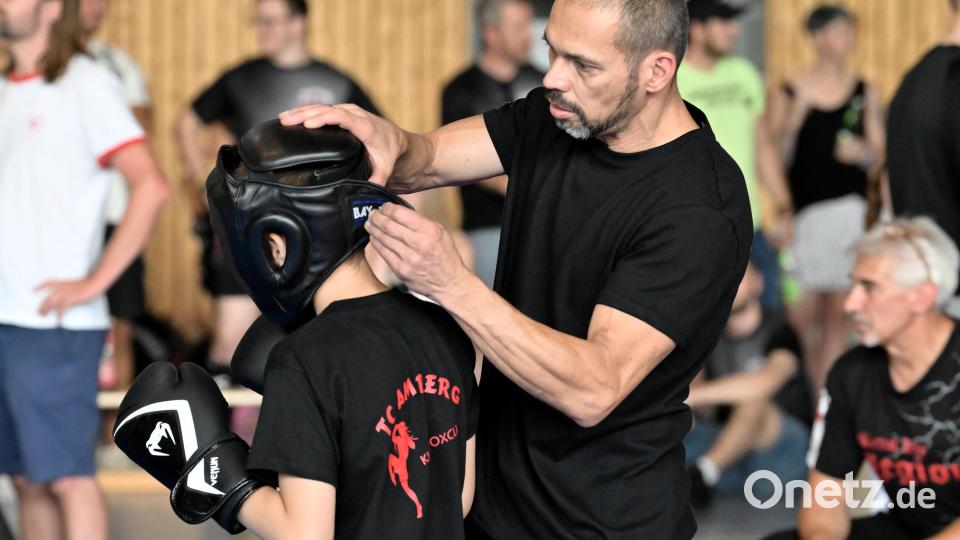 Tomás Àgotai (rechts) vom TC Amberg Kickboxclub passt einen Kopfschutz bei einem Kämpfer an. Bild: Hubert Ziegler