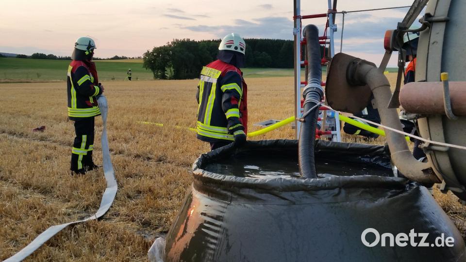 Die Oberlinder Feuerwehrleute bauen einen Wasserübergabebehälter auf dem Feld auf. Bild: dob