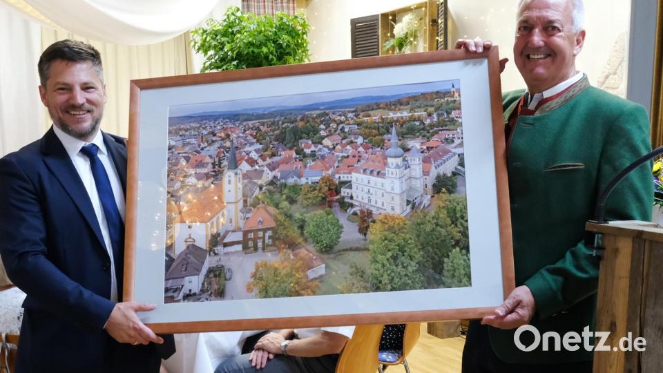 Ein Geschenk für die Gäste aus Straß: Eine Luftaufnahme von Schwarzenfeld. Links Bürgermeister Peter Neumeier, rechts der Straßer Bürgermeister Reinhold Höflechner. Bild: mab