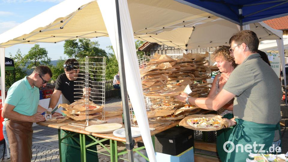 Unentwegt waren die freiwilligen Helfer dabei, die Pizzen richtig zu belegen. Bild: bey