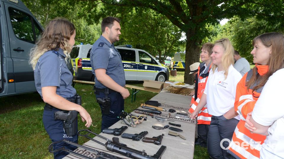 Die Beamtinnen und Beamten des Zolls zeigen den interessierten Besucherinnen die sichergestellten widerrechtlich eingeführten Waffen. Bild: bey