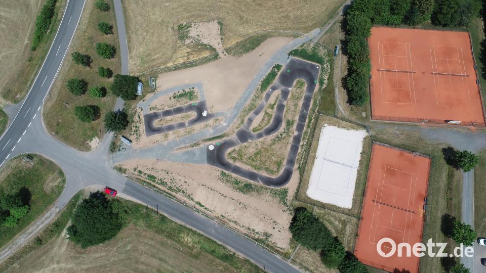 Noch fehlt aufgrund der Wetterlage mit den ausbleibenden Niederschlägen die von der Unteren Naturschutzbehörde geforderte Eingrünung. Zwischen dem Kinderpiumptrack (links) und dem &quot;normalen&quot; Pumptrack befand sich früher die lange Hecke. Am unteren Bildrand unterhalb der dortigen Straße befindet sich leicht versetzt der Kläranlage. Links ist mit einem kleinen Ausschnitt die Pressather Straße zu sehen. Rechts im Bild sind die Tennisanlagen der Tennisgemeinschaft Parkstein. Bild: bey