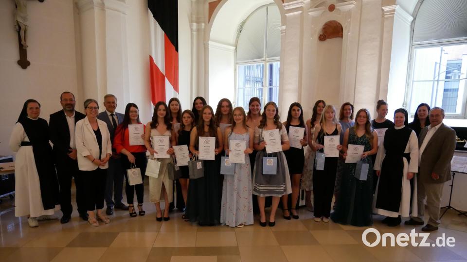 Im Bild die 15 Absolventinnen mit einer Eins vor dem Komma zusammen mit der Schulfamilie und Ehrengästen. Bild: hmr