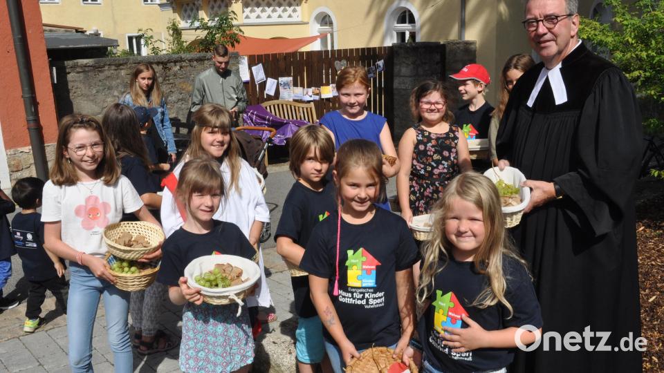 Mit dem Plößberger Pfarrer Klaus Weber brachten die Kinder aus dem Gottfried Sperl Kindergarten mit Brot und Weintrauben gefüllte Körbchen, die sie an die Gottesdienstbesucher verteilten. Bild: dob