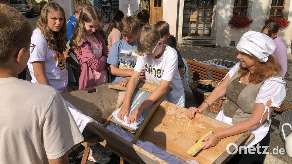 Bei der Historische Stadtführung durften die Mädchen und Buben selbst ausprobieren wie früher die Wäsche gewaschen wurden. Bild: krb