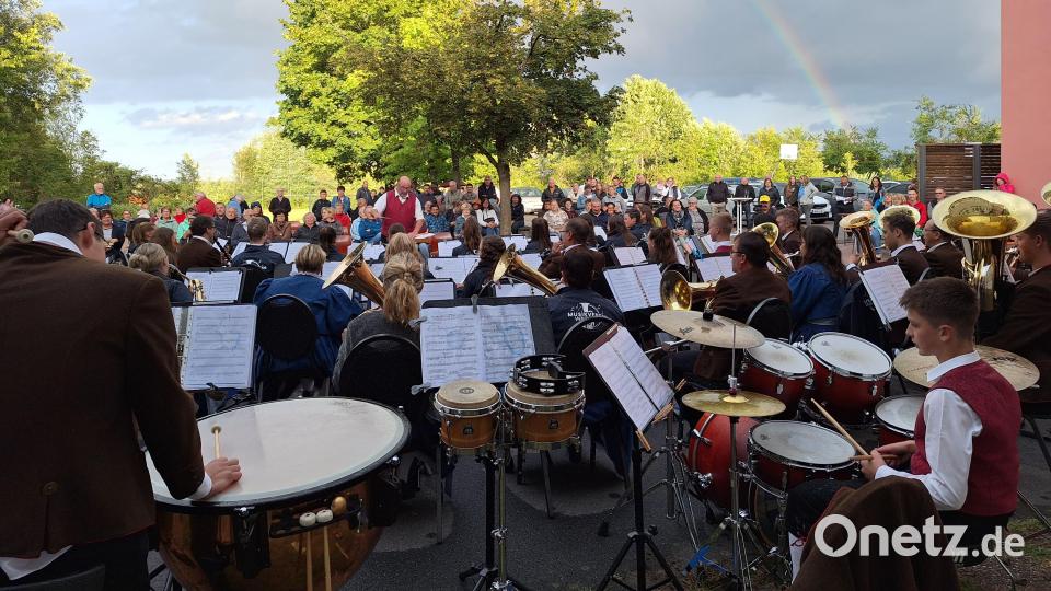 Das Große Vereinsorchester Waidhaus unter Leitung von Hermann Mack lässt sich von einem kurzen Regenschauer nicht aus dem Takt bringen. Im Hintergrund bildet ein Regenbogen einen schönen Rahmen für das Konzert. Bild: bey