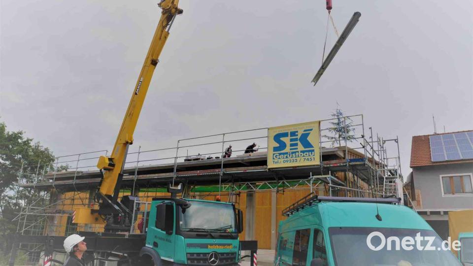 Mit einem Kran befördert die Holzbaufirma Riedl aus Waldthurn das benötigte Baumaterial auf das Dach. Bild: gz
