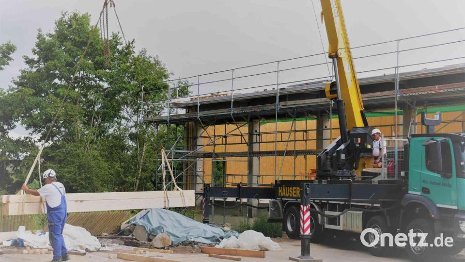 Die Holzbaufirma Riedl hievt mit dem Kran vor der Hebfeier die letzten Balken auf das Dach. Bild: gz