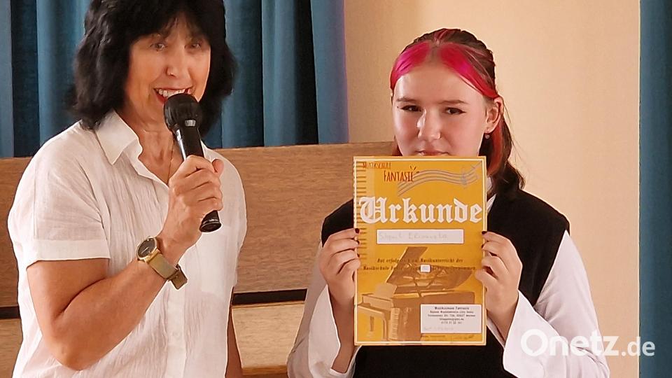 Für fünf Jahre Unterricht erhält die Schülerin Liza Speiht eine Urkunde von ihrer Musiklehrerin Lilia Gette. Bild: R. Kreuzer