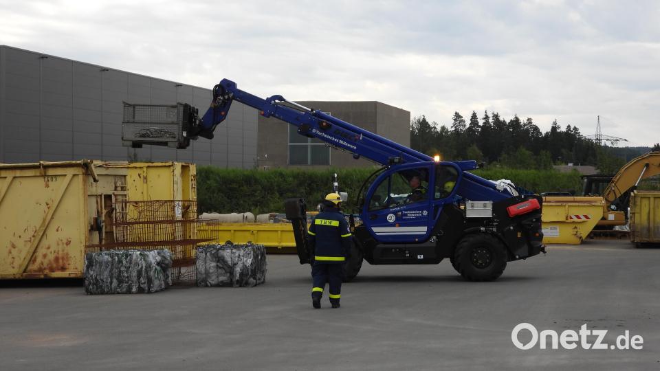 Um überhaupt an den Container zu kommen, muss dieser erst mit dem Teleskoplader des THW Weiden von größeren Gegenständen und Gitterboxen freigeräumt werden. Bild: Richard Meiler/exb