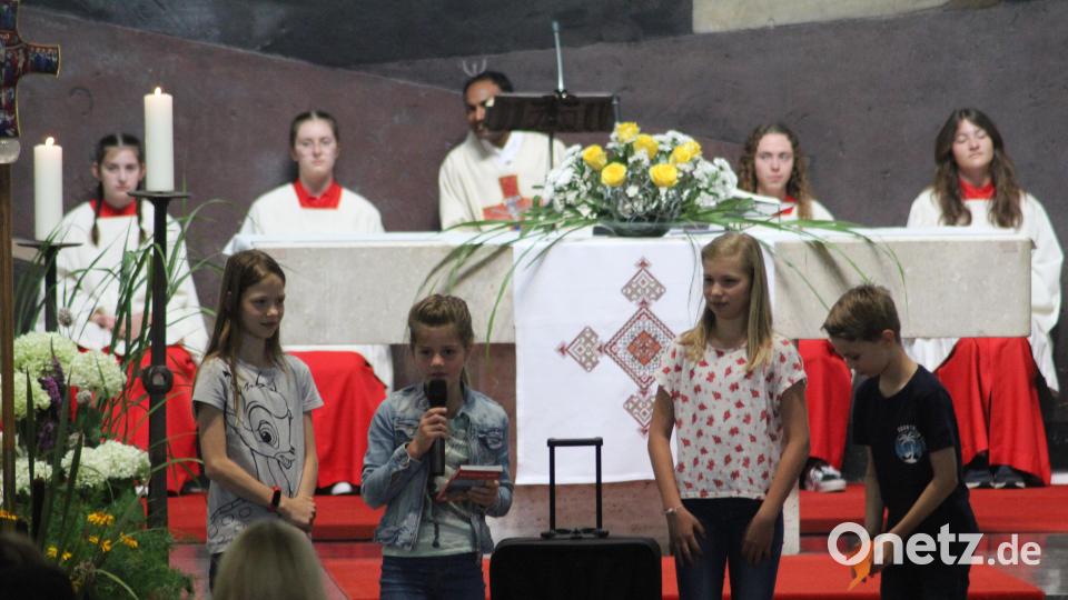 Kinder der Pfarrei packen dem scheidenden Pfarrer einen Koffer. Leonie bringt ihm eine Wanderkarte, dass er sich in der neuen Heimat nicht verirrt. Bild: kki