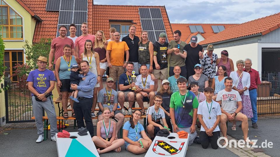 Das Siegerteam William Derma (links) und Johannes Kraus (rechts) mit dem neuen Wanderpokal in der Hand. Gespendet hat ihn Bürgermeister Christian Porsch (mit Sohn David auf dem Arm). Bild: Lothar Ziegler/exb