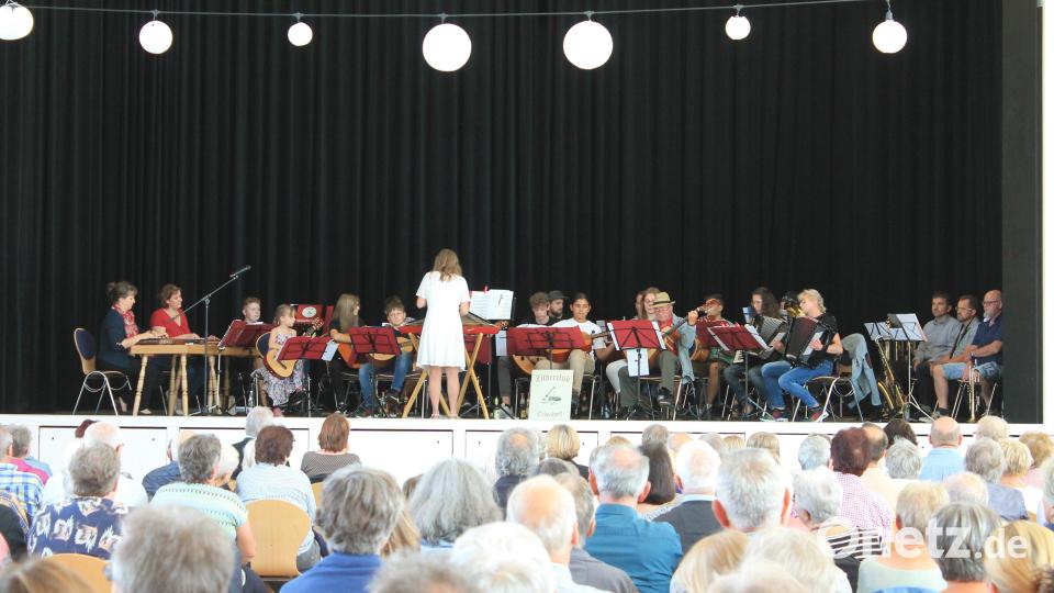19 Zitherclubmusikanten mit Dirigentin Veronika Hille (vorne stehend) und ein kleines Bläserensemble unter der Leitung von German Martetschläger (rechts außen) musizierten in der Stadthalle Erbendorf. Die Einnahmen gehen zugunsten von Asante. Bild: ban