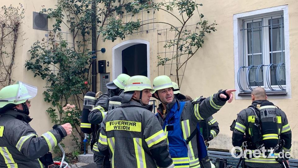 Feuerwehrleute sind am Pfarrplatz in Weiden im Einsatz. Dort ist am Freitagvormittag ein Feuer in einer Küche ausgebrochen. Bild: Gabi Schönberger