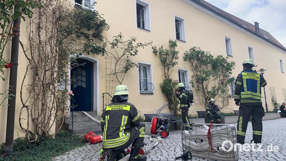 Feuerwehrleute sind am Pfarrplatz in Weiden im Einsatz. Dort ist am Freitagvormittag ein Feuer in einer Küche ausgebrochen. Bild: Gabi Schönberger