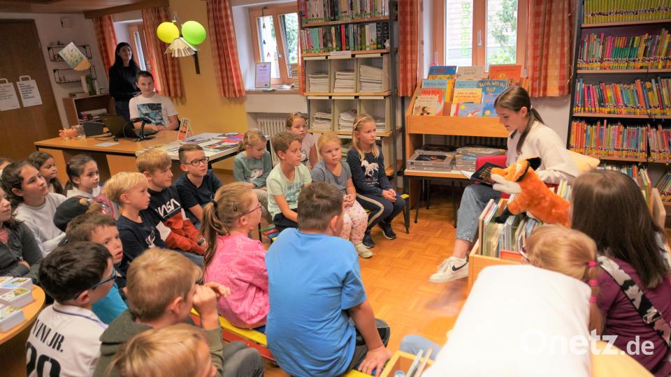 Marlene Greiner liest aus dem Buch &quot;Zippel – das wirklich wahre Schlossgespenst&quot;. Die Ferienkinder und der Büchereifuchs hören gespannt zu. Bild: fvo