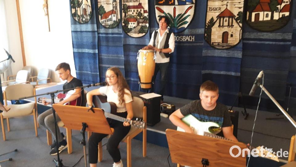 Musiklehrer Christian Nesner stellt seine Gitarrenklasse vor. Alle erhalten viel Beifall für ihre musikalische Reise. Bild: gi